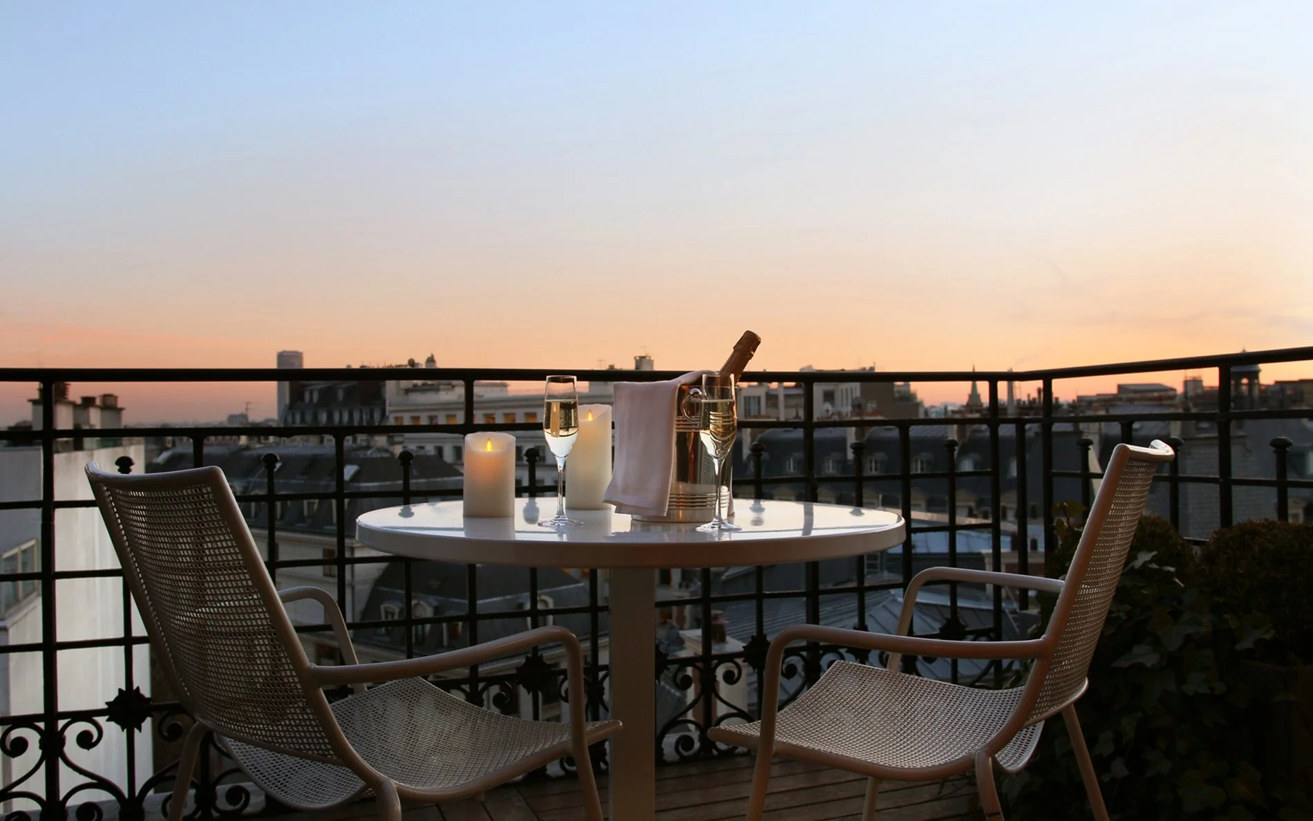 Terrasse privée de la Junior Suite de l’Hôtel San Régis, ambiance romantique au champagne à la tombée du jour.